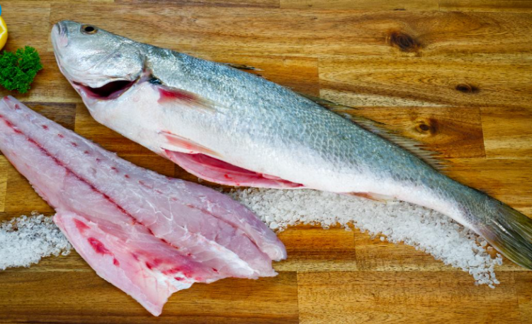 Mullaway Fillet on a wooden cutting board with salt and pepper.