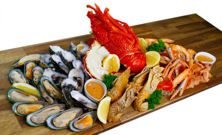Gourmet seafood platter with lobster, mussels, and prawns on a wooden board.